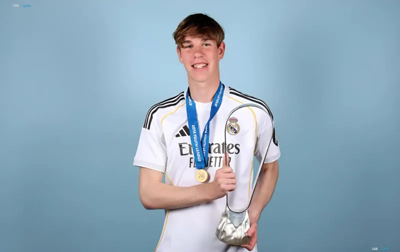 Iwan Woloschin im Trikot von Real Madrid mit UEFA Youth League-Medaille und Trophäe, die seinen Erfolg im Jugendteam vor seinem Debüt für die erste Mannschaft symbolisieren