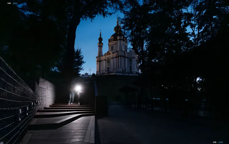 Night view of a church in Kyiv with illuminated domes, symbolizing calm and stability in the city amid rumors of lockdowns
