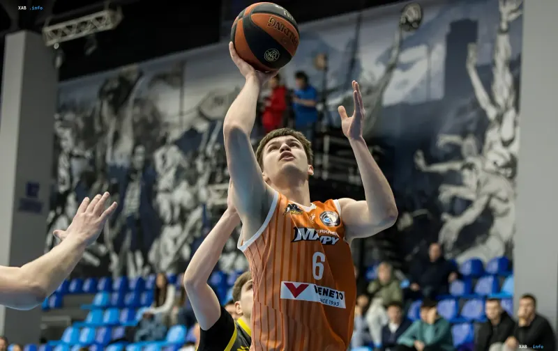 Nazar Kholod in der orangefarbenen 'Kyiv-Basket'-Trikot macht einen Wurf während eines Spiels und zeigt seine Leistung vor der Saison 2026/27