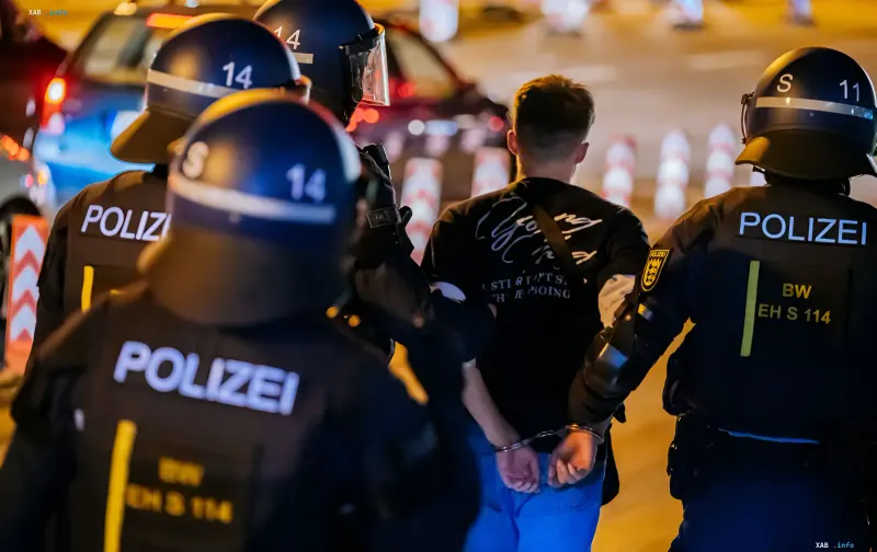 German police officers in protective helmets detain a man in Stuttgart, linked to a Russian espionage case