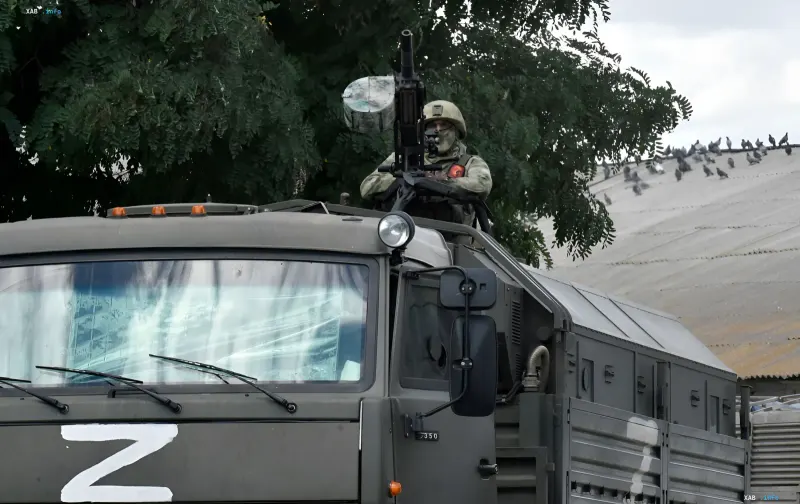 Russian soldier with a machine gun on an armored vehicle with the letter Z, preparing to attack Ukrainian infrastructure