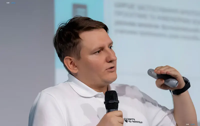 Stellvertretender Leiter der ukrainischen Wiederherstellungsagentur mit Mikrofon und Fernbedienung – im Zentrum des Skandals wegen Parkplatzmiete und Verträgen mit einem Energoatom-Lieferanten