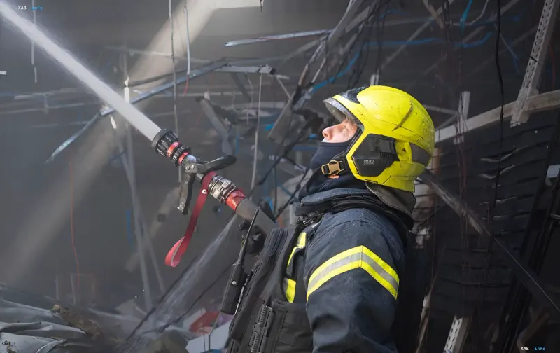 Пожарний ліквідує пожежу після удару дронів по Одеській області: струя води спрямована на пошкоджену будівлю з уламками та обірваними проводами