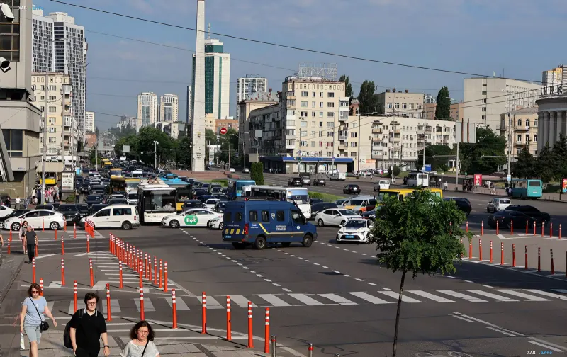 Ограничения движения в центре Киева: дорожные барьеры и конусы на оживлённой улице с автобусами, такси и полицейским фургоном на фоне визита иностранных делегаций