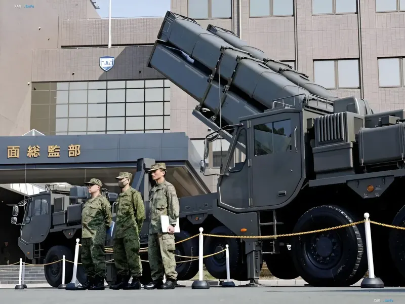 Японский зенитно-ракетный комплекс на колёсном шасси в боевом положении у здания штаба, военнослужащие Сил самообороны Японии — рост оборонного бюджета вызвал критику Пхеньяна