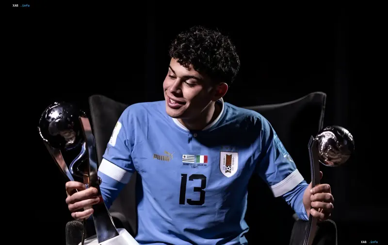 Uruguayan footballer Matturo in the Uruguay national team jersey number 13 holding the Golden Ball and Silver Ball trophies from the 2023 World Cup