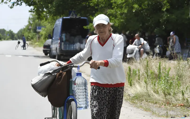 Herson resident with a bicycle loaded with belongings amid evacuation after strikes on the thermal power plant
