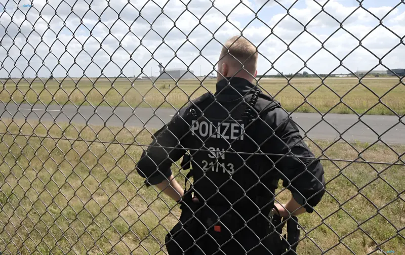 German police officer behind a fence at an airfield: heightened security in Germany after the drone attack in Leipzig
