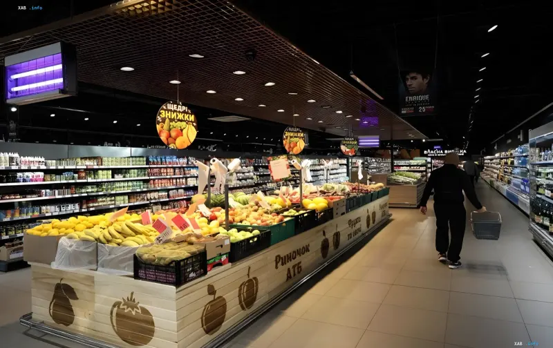 Innenansicht eines laufenden ATB-Supermarkts in Cherson: Insel mit frischem Obst und Gemüse sowie Kunden