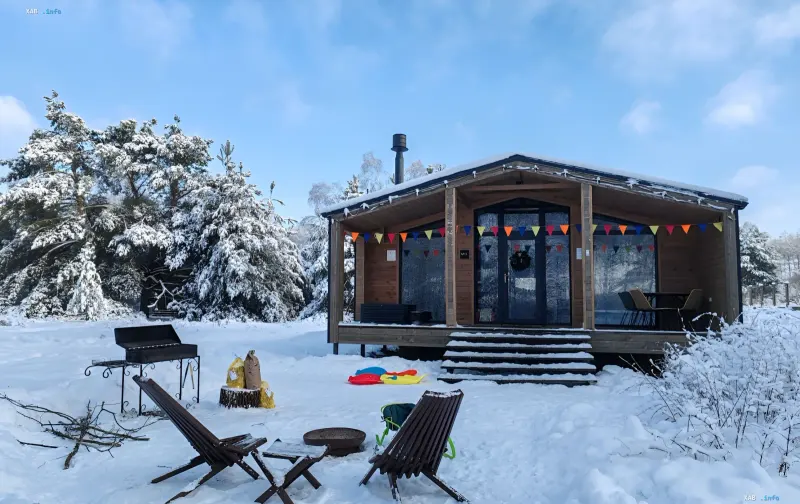 Snow-covered rental cabin with a covered porch, fire pit and firewood stack — what to check in a 20-minute winter home test