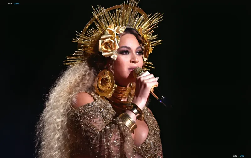Beyoncé auf der Bühne in einer goldenen Krone und glitzerndem Outfit, singend in ein Mikrofon