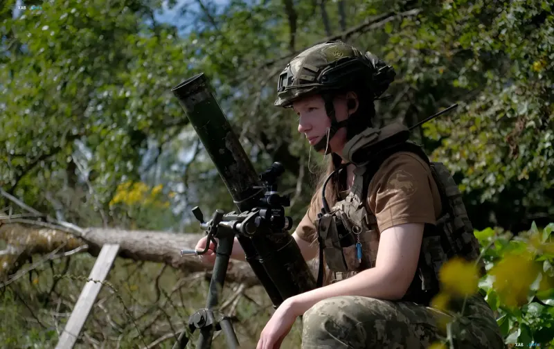 Українська військовослужбовиця з мінометом на передовій під час бойових дій на фронті