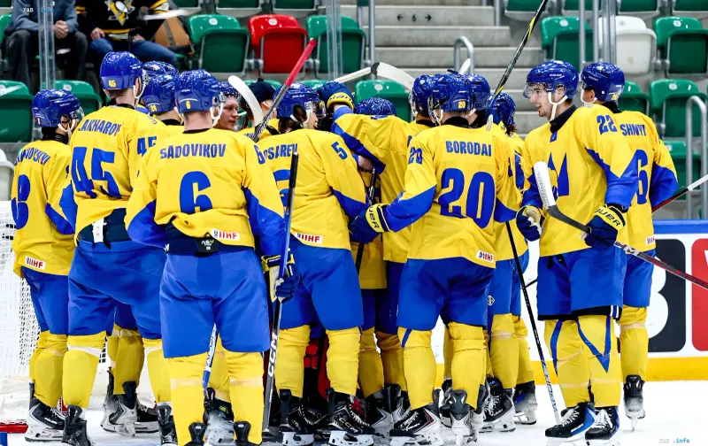 Spieler der ukrainischen Eishockey-Nationalmannschaft in gelb-blauen IIHF-Trikots versammeln sich auf dem Eis vor dem Top-Division-Weltmeisterschaft 2027