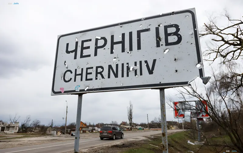 Дорожный указатель Чернигов с пулевыми пробоинами на фоне разрушенных зданий — Черниговщина в зоне возможных боевых действий