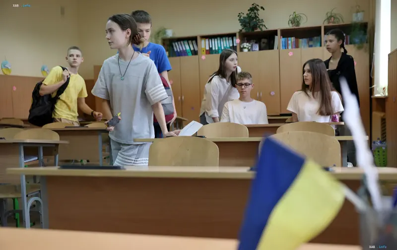 Школярі в класі на тлі українського прапора — ілюстрація до результатів PISA-2025 про розрив у навчанні між селами та містами України