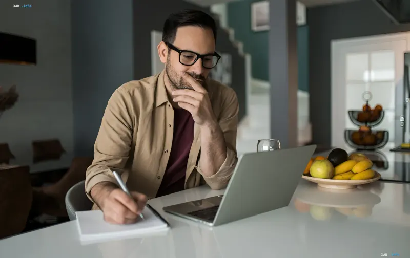 Man at a laptop noting details in a notebook — illustration of filing harm claims on the RD4U platform