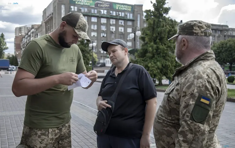 Сотрудники ТЦК проверяют документы у мужчины на улице в Днепре