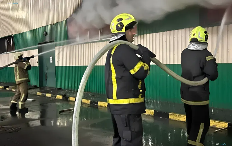Firefighters extinguish a fire at a food production facility in Bila Tserkva, directing a water stream from a hose onto the burning building