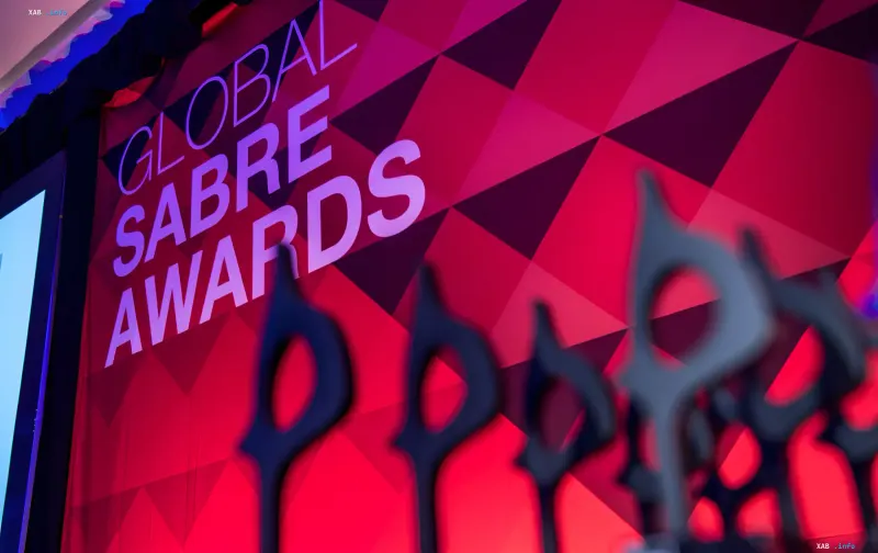 Logo der Global SABRE Awards vor geometrischem rot-pinkem Hintergrund mit Preissilhouetten — DTEK gewann die Auszeichnung für die Kampagne „Das Licht hält stand“