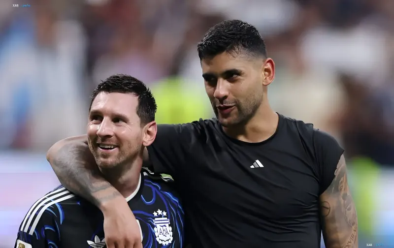 Cristian Romero embraces Lionel Messi in the Argentina national team kit — the moment of passing the captain's armband of the Albiceleste