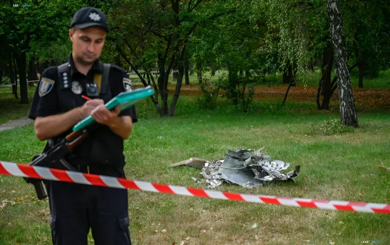 Police officer documents the scene at a drone debris crash site in a Kyiv park during the September 10 air raid