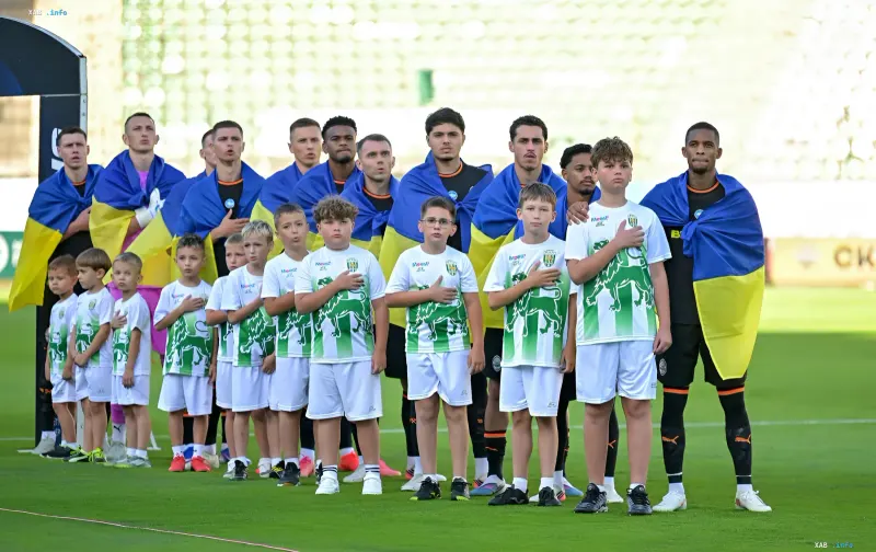 Shakhtar players draped in Ukrainian flags with child mascots on the pitch ahead of the Champions League match against PSV in Eindhoven