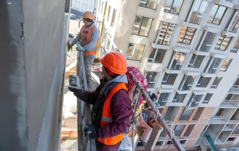 Bauarbeiter auf Gerüsten bei der Fassadenveredelung: Lohnunterschied für Handwerker in den Regionen der Ukraine erreicht 106 %