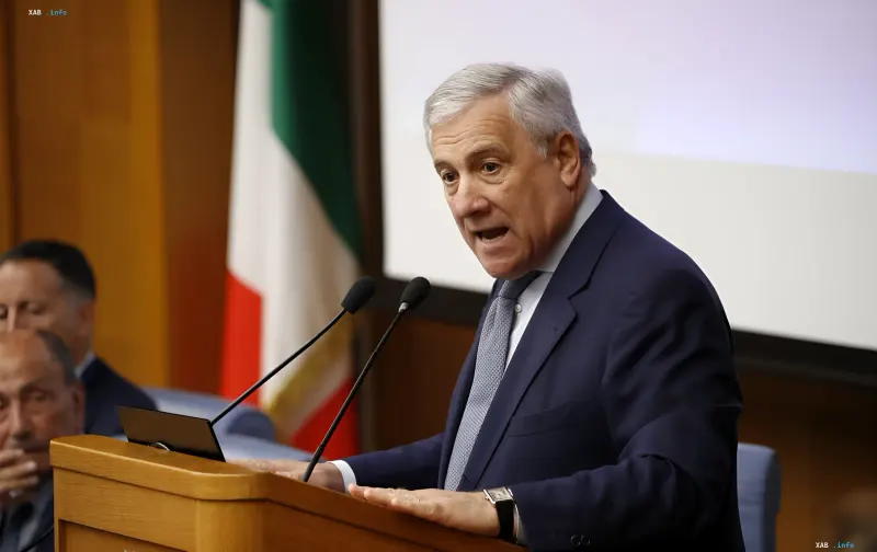 Antonio Tajani spricht an einem Rednerpult mit italienischer Flagge im Hintergrund und fordert Selenskyj auf, die gesamte EU in Friedensinitiativen einzubeziehen