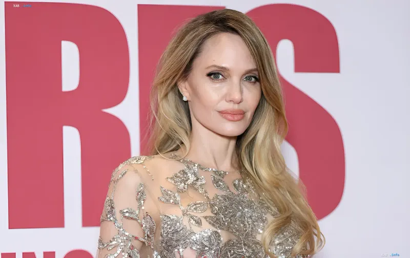 Angelina Jolie in a shimmering embroidered gown against a logo backdrop, where in a L'Officiel interview she spoke about a new chapter of life after her children grew up
