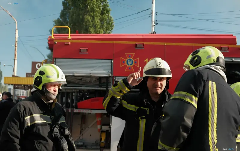 Firefighters at a rescue truck on the scene of a fire in an office building in Kyiv's Podil district after a drone strike