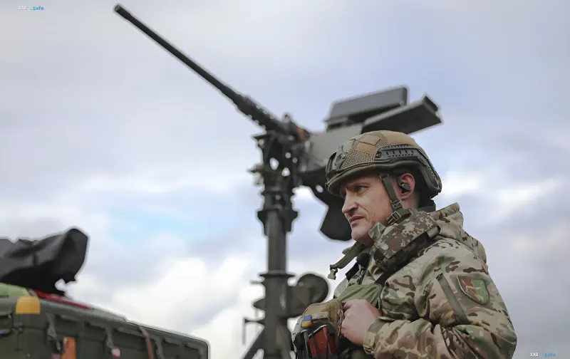 Украинский военный на фоне зенитной установки в контексте ночного ракетно-дронного удара по Украине