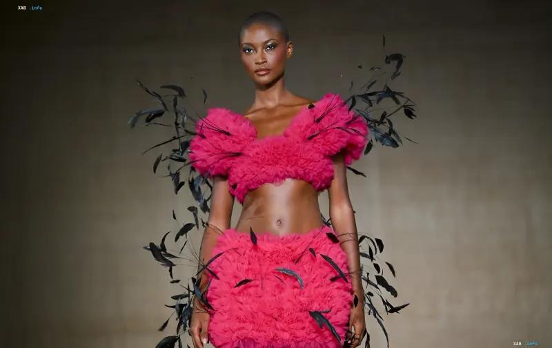 Model in einem pinken Rüschen-Kleid aus Textil mit schwarzen Federn auf dem Laufsteg der New York Fashion Week — eine Alternative zu Naturfell
