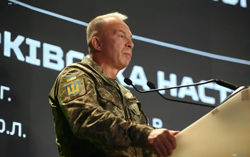 Презентация очерка о Харьковской наступательной операции 2022 года в Киеве: военный в камуфляжной форме с нашивкой ВСУ у трибуны с микрофонами