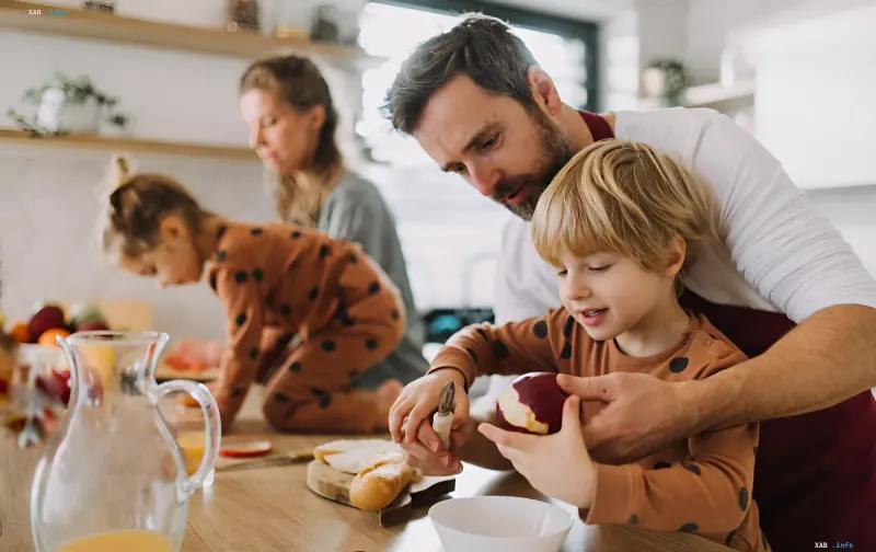 Vater lehrt seinen Sohn, einen Apfel zu schälen, in der Küche, Illustration zu elterlichen Rechten und Pflichten ohne Traustempel