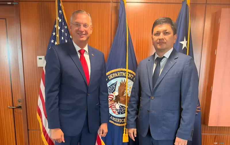 Ukraine and US officials meet to discuss veteran rehabilitation experience exchange: Kim and Collins in front of national flags and departmental seal