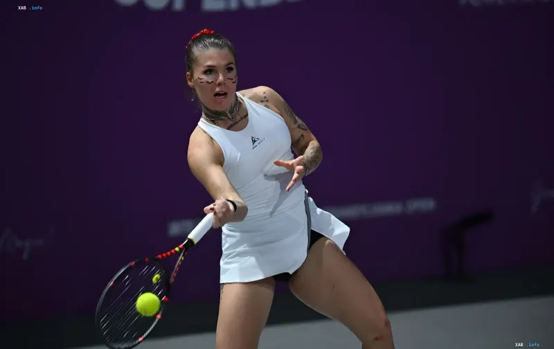 Ukrainian tennis player Oleinikova in a white outfit hitting the ball on the US Open court, where she earned the prize money she later donated to the Spalah battalion