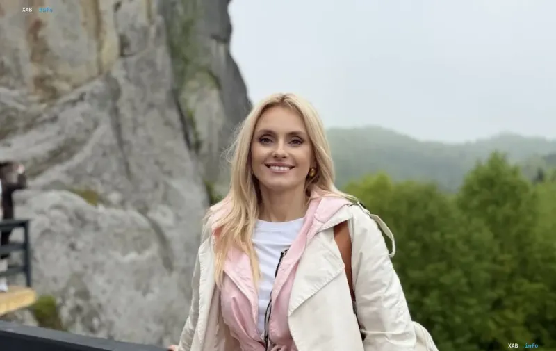 Iryna Fedishyn in der 32. Schwangerschaftswoche in einem zarten Look vor einer Berglandschaft
