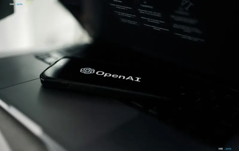 Smartphone mit OpenAI-Logo auf dem Bildschirm vor einem Laptop — Ankündigung der aktualisierten GPT-6-Modelle Sol und Luna