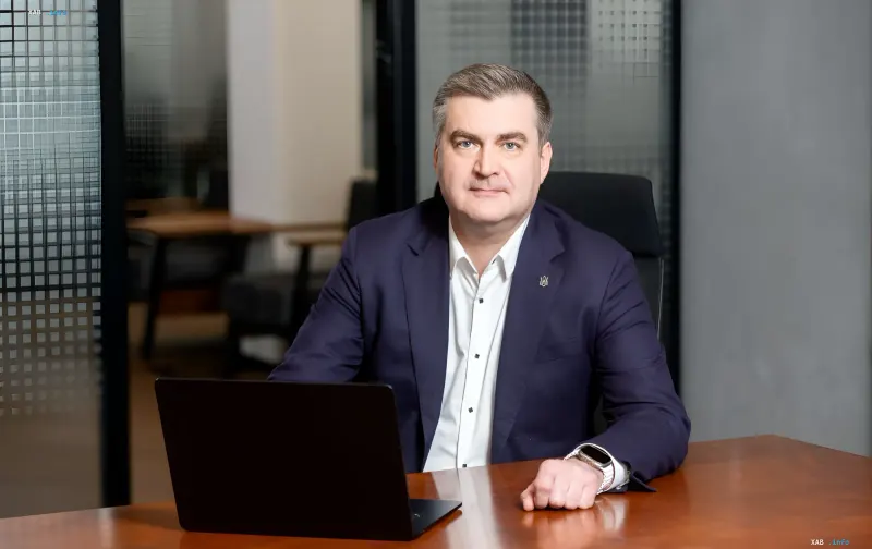 Член правління ПриватБанку Дмитро Мусієнко за робочим столом з ноутбуком в офісі