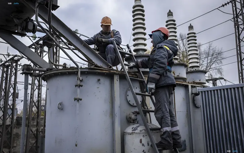 Українські фахівці у захисному екіпіруванні ремонтують трансформатор на електричній підстанції