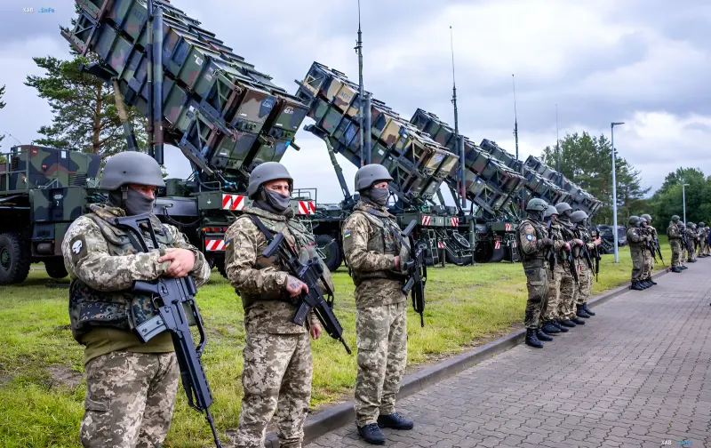 Військовослужбовці в камуфляжі стоять на тлі зенітно-ракетних комплексів Patriot під час навчання