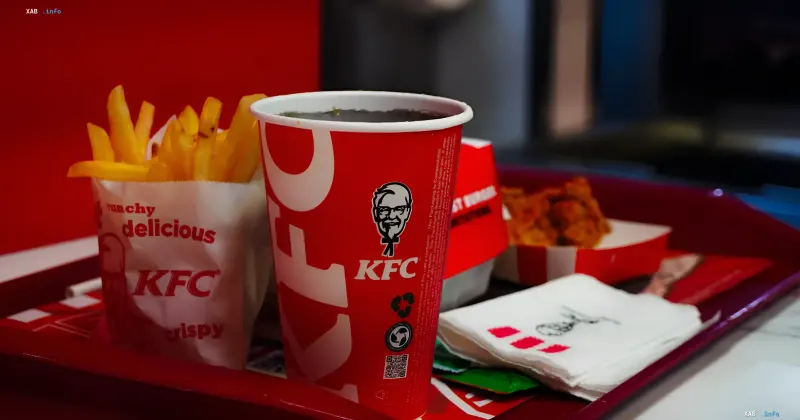 Поднос с едой и напитками из KFC, включая картофель фри в фирменном стаканчике с логотипом