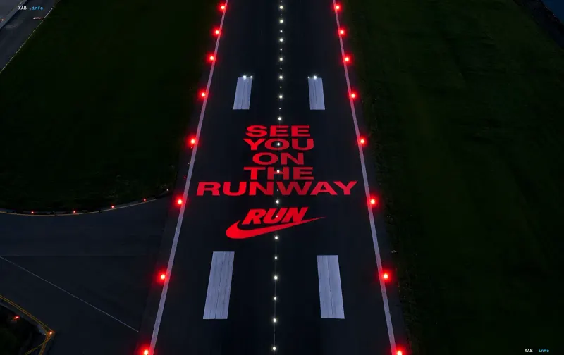 Nächtliche Start- und Landebahn mit roter Beleuchtung und dem Schriftzug See you on the runway sowie dem Nike Run Logo.