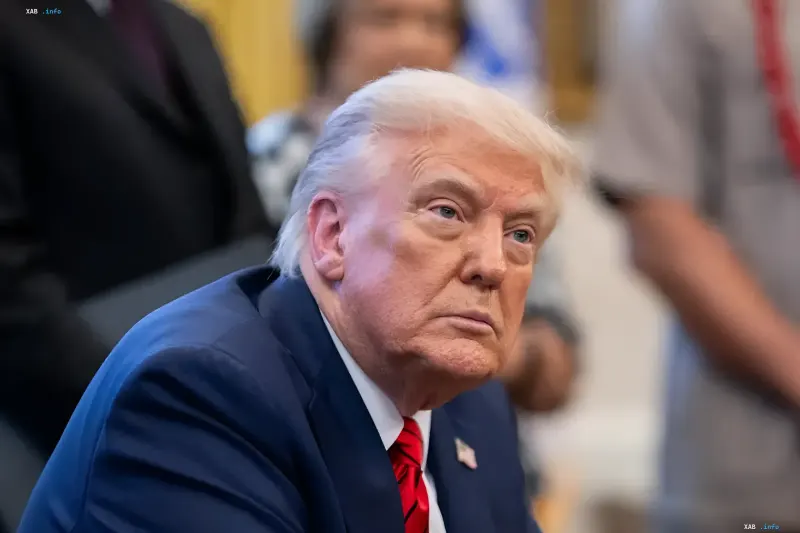 Дональд Трамп в синем костюме и красном галстуке выглядит серьезным во время выступления в Белом доме
