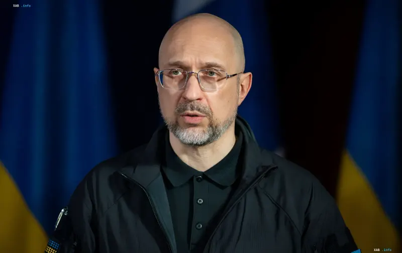 Prime Minister of Ukraine Denys Shmyhal speaking against the backdrop of official Ukrainian flags