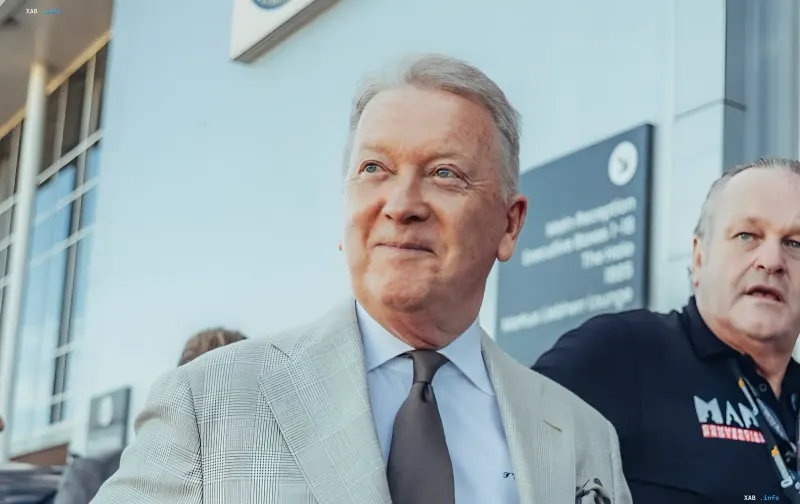 British promoter Frank Warren in a light suit in front of a sports arena