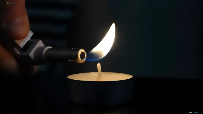 Nahaufnahme einer brennenden Teelichtkerze und eines Brenners vor dem Hintergrund von Stromausfallrisiken