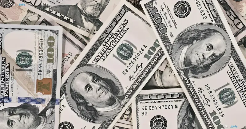 A pile of US one hundred dollar bills lying on a table