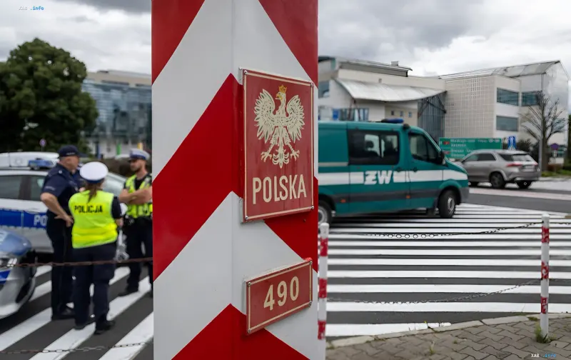 Пограничный столб с гербом Польши и полицейские автомобили на контрольно-пропускном пункте
