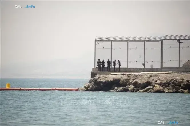 Border fence on the sea coast and security personnel against the background of the sea